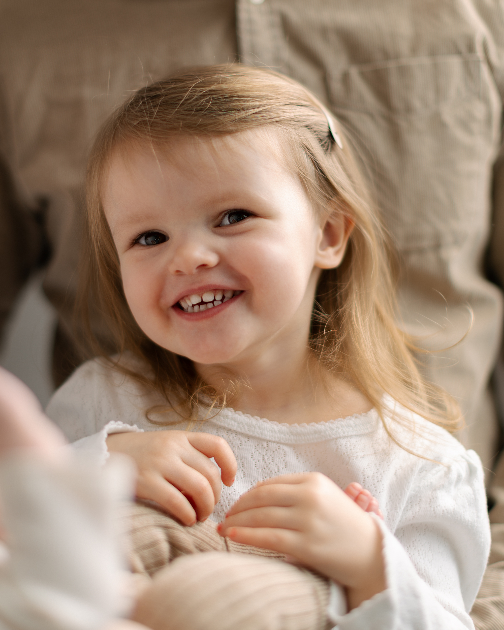 Smilende jente sitter på fanget