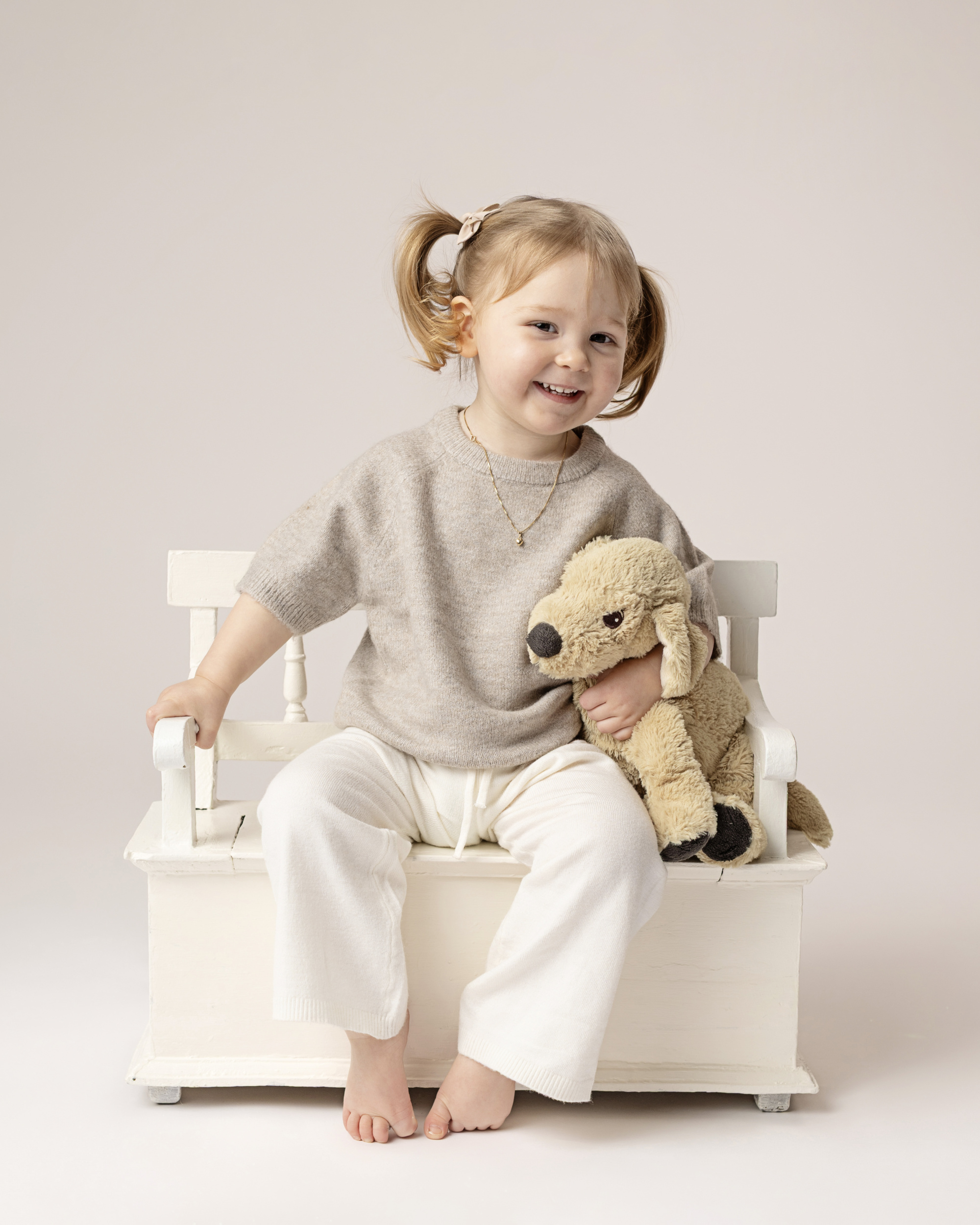 Liten jente med kosebamse og benk