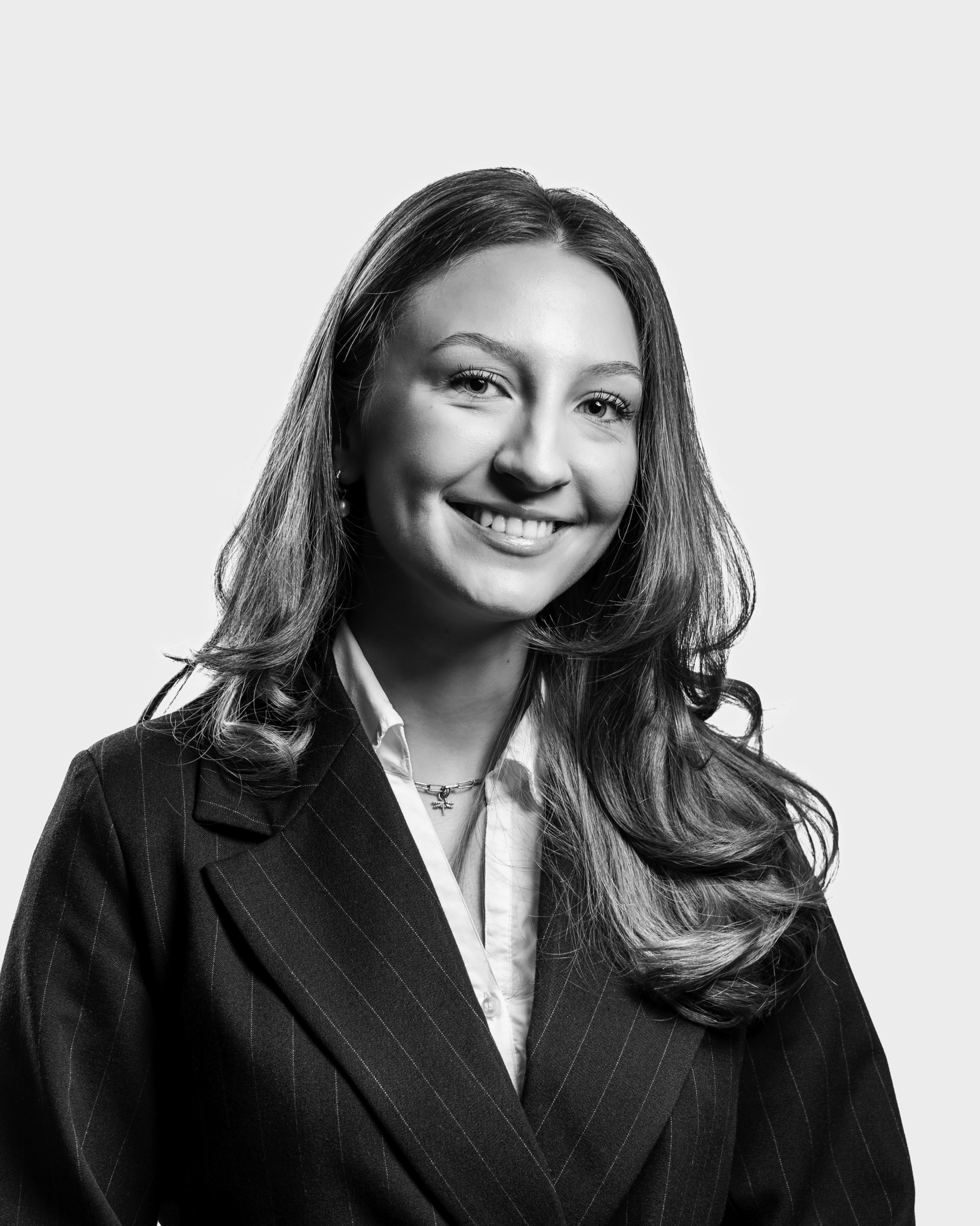 Kvinne i dressjakke smiler.